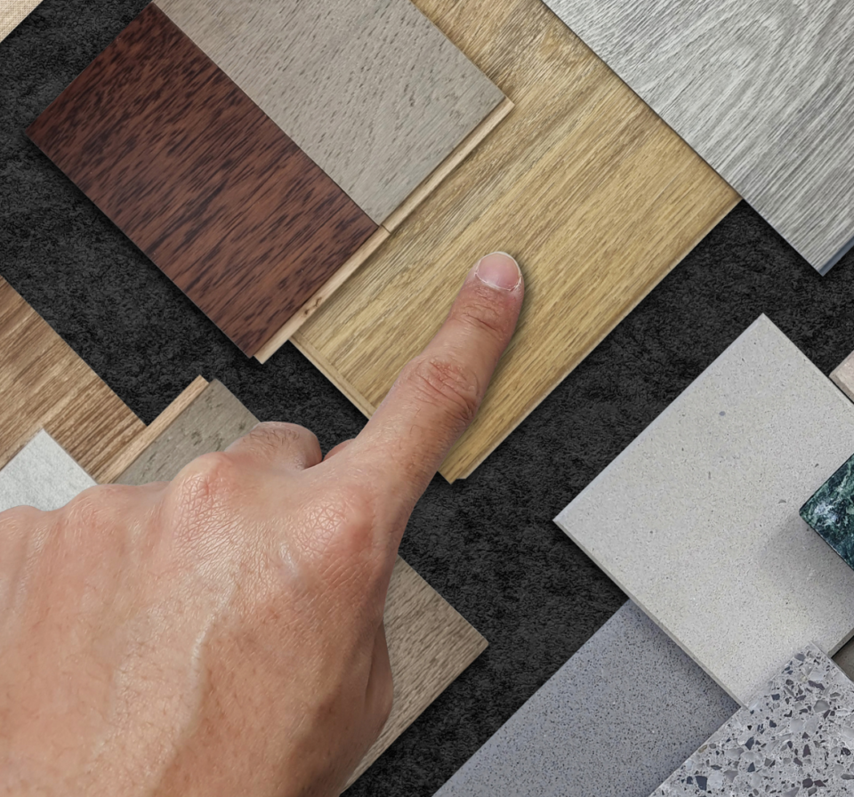 Hand pointing to a selection of tiles, helping choose the best tile option for a home renovation or construction project.