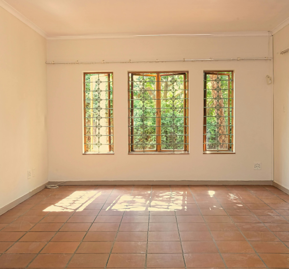 Square block tiles installed in a living room with a craftsman using a tool to cut tiles for a precise fit.